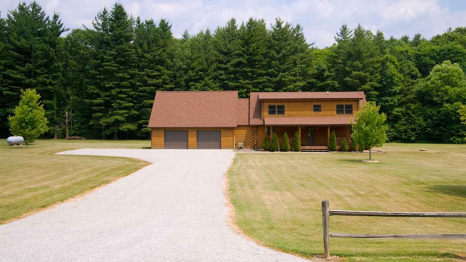 A view of a house with a gravel driveway