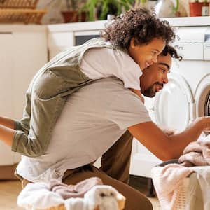 A father with his son loading the washing machine