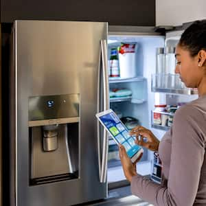 Woman using smart refrigerator