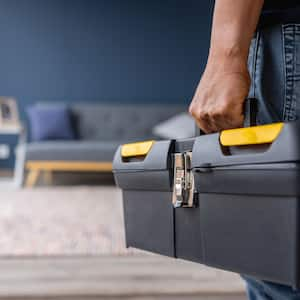 Close-up on an electrician carrying a toolbox