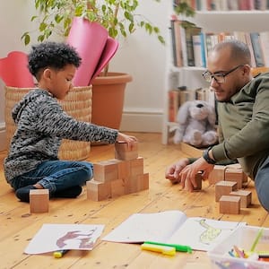 Dad and son build blocks on hardwood floors
