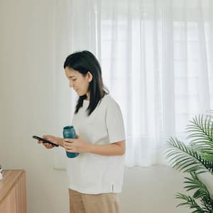 Woman setting up security camera in the house