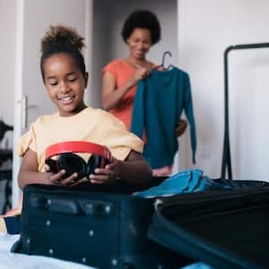 mother and daughter packing a suitcase