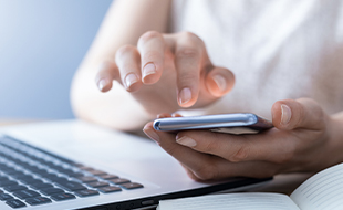 person using laptop computer and phone