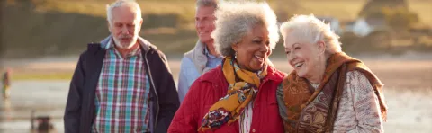 Two older men walking behind two older women smiling.