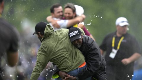 Canadian professional golfer Adam Hadwin, left, is stopped by a security guard while he tries to celebrates with Nick Taylor, of Canada, after Taylor won the Canadian Open golf tournament in Toronto, Sunday, June 11, 2023. (Andrew Lahodynskyj/The Canadian Press via AP)