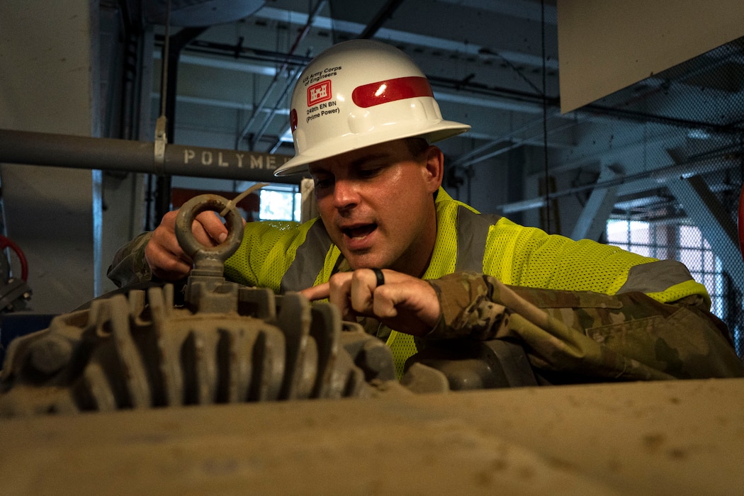 A man in a hardhat inspects machinery used at the Washington Aqueduct.