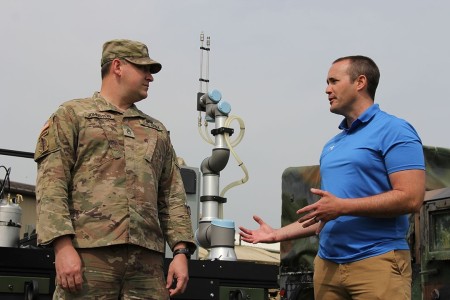 Autonomous Equipment Decontamination project lead, Matt Brown, discusses the system with Col. Christopher Grice, DTRA’s Acting Director of Chemical/Biological Technology Department during its field demonstration at CBOA 23.
