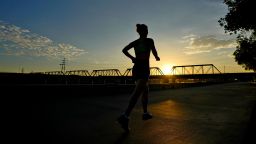 A runner jogs along Tempe Town Lake at sunrise, Wednesday, July 12, 2023 in Tempe, Ariz. Even desert residents accustomed to scorching summers are feeling the grip of an extreme heat wave smacking the Southwest this week. Arizona, Nevada, New Mexico and Southern California are getting hit with 100-degree-plus temps and excessive heat warnings. (AP Photo/Matt York)