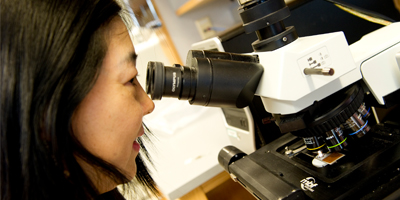 Woman looking into a microscope