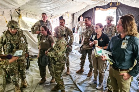 U.S. Army Maj. Gen. Tracy L. Smith, commanding general of the 807th Medical Command (Deployment Support), far left, inspects the handheld Analyzer Traumatic Brain Injury (ATBI) system as part of Global Medic, a combat support training exercise, Fort Hunter Liggett, Calif., June 17, 2023. Smith and Soldiers from across the U.S. Army and Army Reserve took part in the exercise to increase their medical treatment capabilities in a real-world large-scale combat operation environment. Members of the U.S. Army Medical Materiel Development Activity and the Medical Capability Development Integration Directorate participated in the exercise to gain feedback from end-users on the handheld, deployable TBI biomarker assessment system.