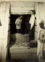 Говард Картер (в глубине) и Артур Мэйс открывают вход в гробницу Тутанхамона. Фото Гарри Бёртона 1923 года