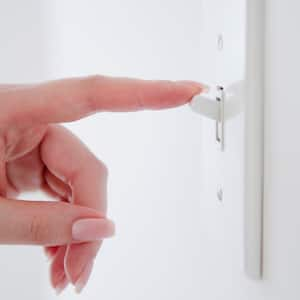 A hand turning on a light switch