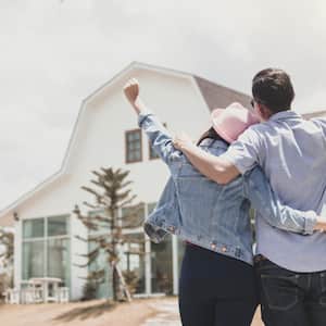 A couple celebrating in front of newly built house