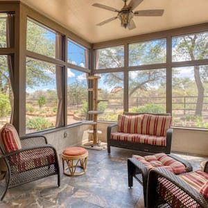 A screened porch with furniture