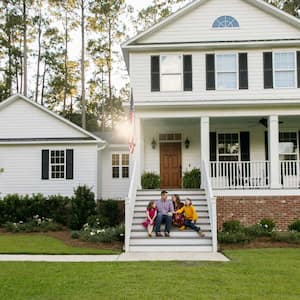 A family sitting outside on the steps of the house