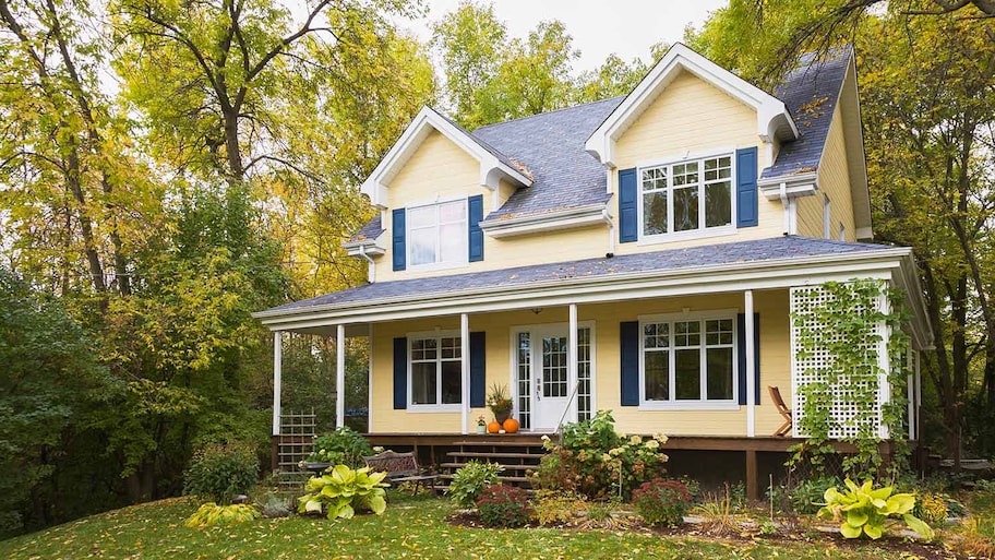 Yellow house surrounded by trees in autumn