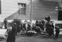 Macedonian Jews leave the Tobacco Monopoly transit camp in Skopje for the deportation trains. Skopje, Yugoslavia, March 1943.
The Jews of Bulgarian-occupied Thrace and Macedonia were deported in March 1943. On March 11, 1943, over 7,000 Macedonian Jews from Skopje, Bitola, and Stip were rounded up and assembled at the Tobacco Monopoly in Skopje, whose several buildings had been hastily converted into a transit camp. The Macedonian Jews were kept there between eleven and eighteen days, before being deported by train in three transports between March 22 and 29, to the Treblinka killing center.