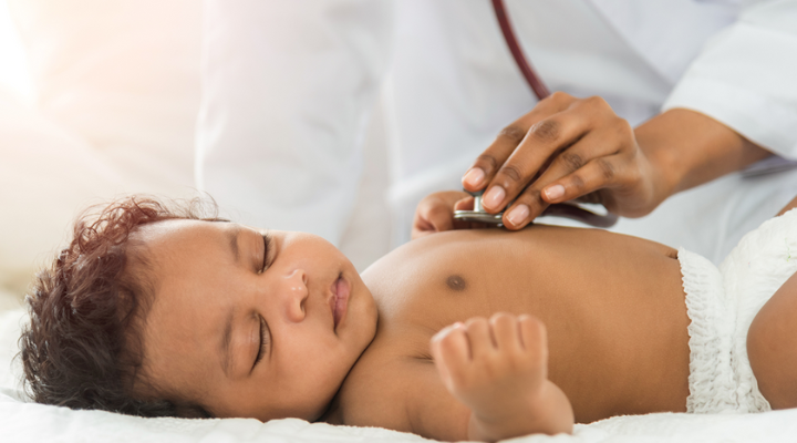 Un médico examinando a un bebé con un estetoscopio.