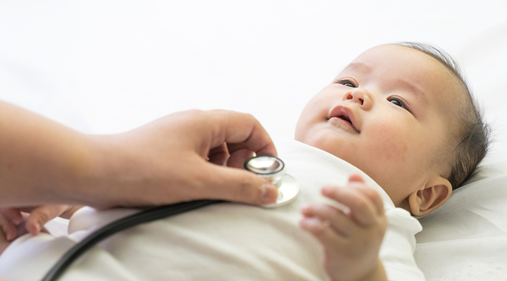 Doctor examining infant with stethoscope