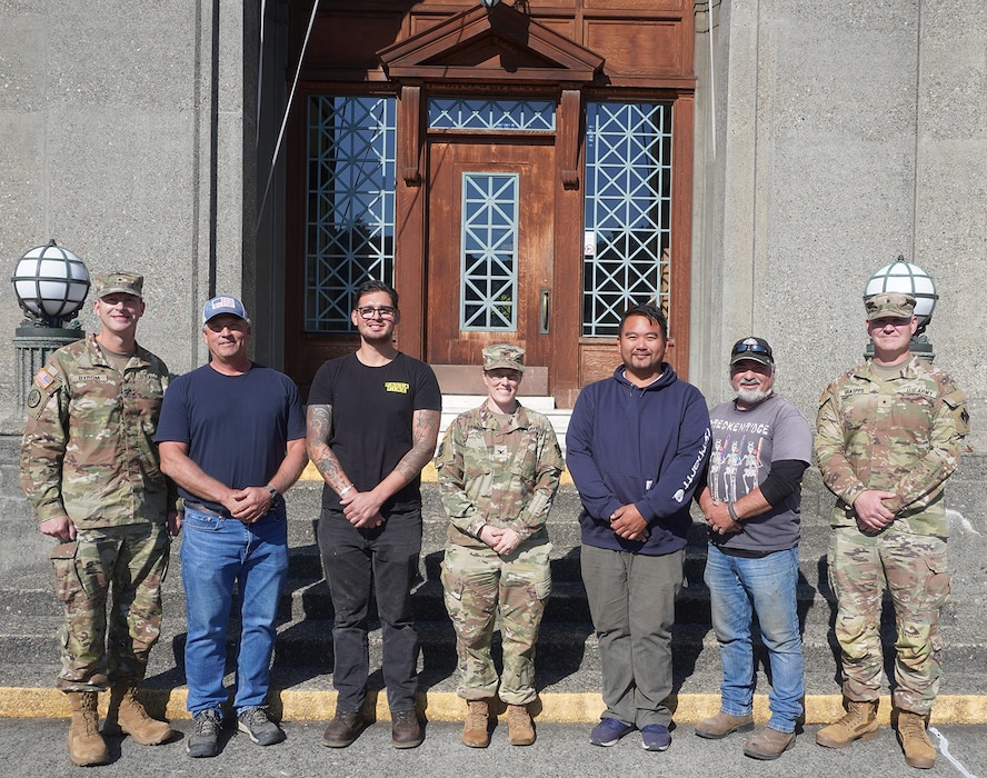 Group photo of Army officers and civilians standing in front of the Administration building of the Lake Washington Ship Canal and Hiram M. Chittenden Locks, Seattle, Washington.