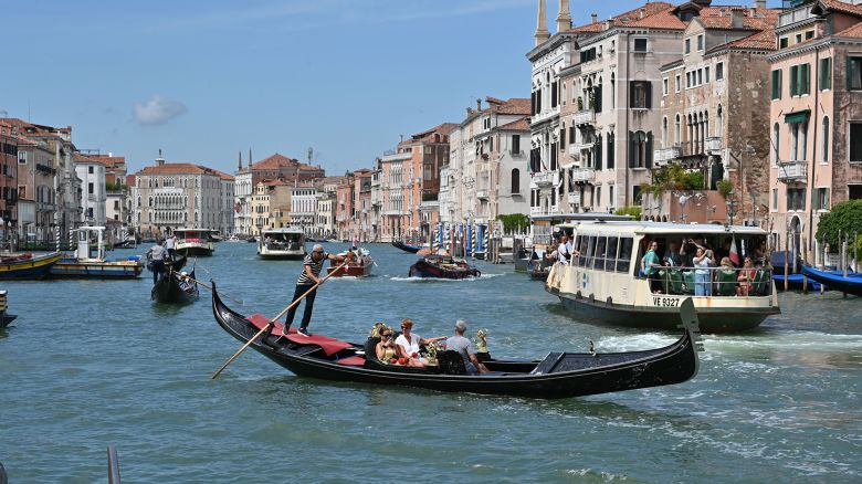 A view taken on July 31, 2023 shows tourists taking a Gondola ride across the Grand Canal in Venice. Unesco is recommending that Venice be placed on the list of World Heritage in Danger, as "insufficient" measures have been taken to fight the deterioration of the site due in particular to mass tourism and climate change, according to a decision made public on July 31, 2023. UNESCO, the UN's cultural wing, put Venice on its heritage list in 1987 as an "extraordinary architectural masterpiece", but the body has warned of the need for a "more sustainable tourism management". (Photo by ANDREA PATTARO / AFP) (Photo by ANDREA PATTARO/AFP via Getty Images)