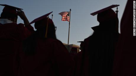 A US flag flies above a building as students earning degrees at Pasadena City College participate in the graduation ceremony, June 14, 2019, in Pasadena, California.