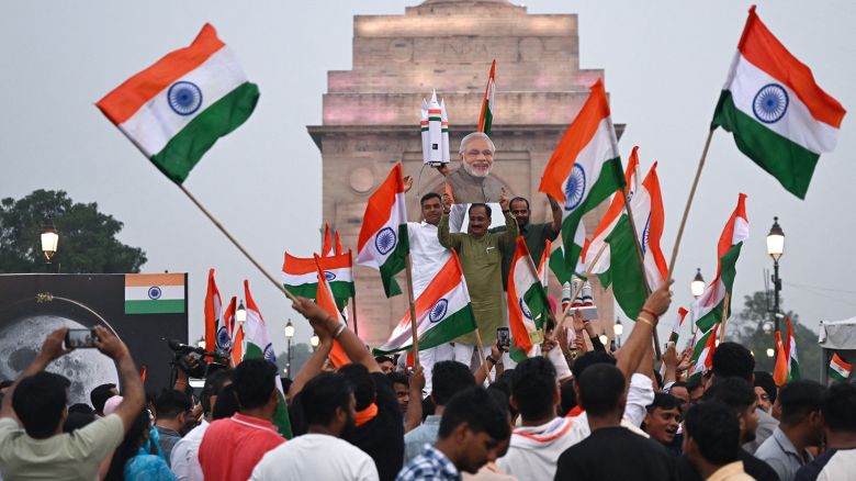 People wave Indian national flags as they celebrate the successful lunar landing of Chandrayaan-3 spacecraft on the south pole of the Moon, in New Delhi on August 23, 2023. 