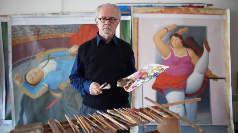 Colombian painter and sculptor Fernando Botero posing in his studio with paint brushes and palette in the hands. Behind him, a painting depicting a torero and another one portraying a dancer resting on the wall. Monte Carlo, 15th March 2012. (Photo by Massimo Sestini/Mondadori via Getty Images)