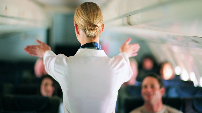 Rear View of Air Stewardess Explaining Aeroplane Safety to Passengers