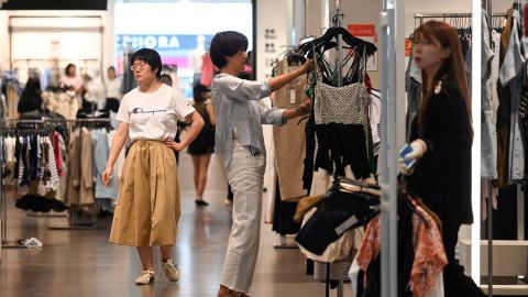 A woman selects clothes at a shopping mall in Beijing on June 15, 2023. 