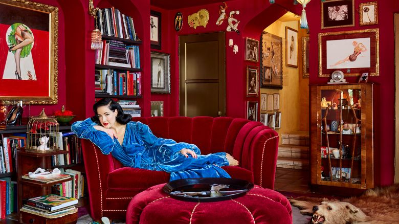 The red room is Von Teese's library. Built-in shelves, designed to mirror the room's preexisting Moorish archways, were added in order to house the star's extensive book collection. (She's a bestselling author herself; Von Teese's latest book, a style guide entitled Fashioning the Femme Fatale, is due next year.) The room showcases a lot of Von Teese's extensive antiques collection—"things were just made more beautifully back then"—but the couch is a reproduction. "I didn't have room for a full-size Art Deco couch, so we created something with a '30s look, but on a smaller scale," she says. Von Teese wears one of her favorite pieces of vintage loungewear, which she happens to collect. "This one's really extravagant," she says. "It has a long train and these long balloon sleeves, and you just can't help but wonder why. Maybe it was made for a movie or something."(Architectural Digest)