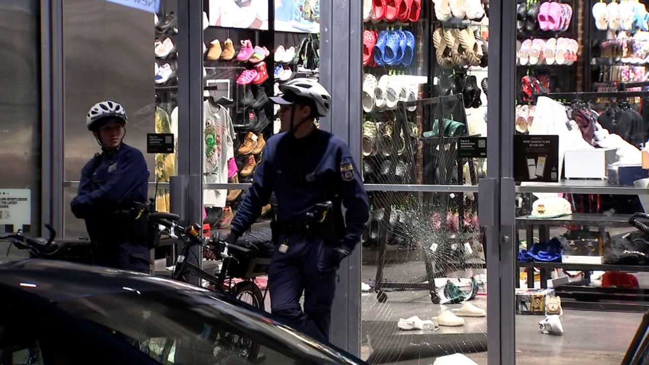 Officers are seen outside a damaged shoe store in Philadelphia on Tuesday.