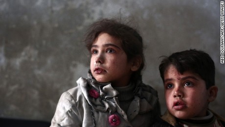 Syrian children look on as they wait for treatment at a makeshift clinic in the besieged rebel town of Douma, on December 21, near Damascus.