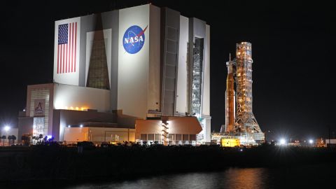 TOPSHOT - The Artemis-1 rocket is rolled out from the Vehicle Assembly Building en route to Launch Pad 39B shortly after midnight at the Kennedy Space Center in Florida on November 3, 2022. - NASA officials aim to launch the massive rocket on November 14 after two previous aborted launch attempts. Artemis-1 is scheduled to journey around the far side of the Moon after launching on a mission lasting four to six weeks before returning home faster and hotter than any vessel before. The mission objectives for this first flight of the Space Launch System (SLS) rocket and Orion spacecraft are to demonstrate its flight worthiness and the ability of Orion's heat shield in lunar reentry conditions. The launch and flight tests must be completed before returning astronauts to the lunar surface for the first time since 1972. (Photo by Gregg Newton / AFP) (Photo by GREGG NEWTON/AFP via Getty Images)