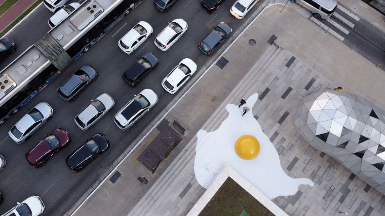 An aerial view shows cars on the street as the "Art Eggcident" installation by Dutch artist Henk Hofstra is seen on the sidewalk of Faria Lima Avenue, in Sao Paulo, Brazil September 18, 2023. REUTERS/Amanda Perobelli     TPX IMAGES OF THE DAY