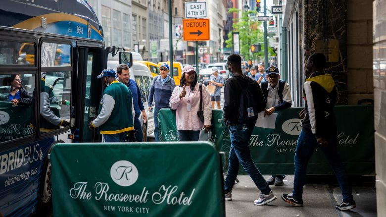 Migrants are seen boarding a bus at the Roosevelt Hotel on May 21, 2023.