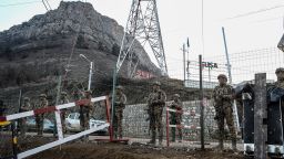 Azerbaijani servicemen stand guard at a checkpoint at the Lachin corridor, the Armenian-populated breakaway Nagorno-Karabakh region's only land link with Armenia, as Azerbaijani environmental activists protest what they claim is illegal mining, on December 26, 2022. - Azerbaijani activists who have blocked the sole road connecting Karabakh with Armenia rejected on December 26 Yerevan's accusations of provoking a humanitarian crisis in the enclave. But locals in Karabakh interviewed by AFP decried the dire consequences of the blockade, which they say is aimed at chasing ethnic Armenians from the region. (Photo by TOFIK BABAYEV / AFP) (Photo by TOFIK BABAYEV/AFP via Getty Images)