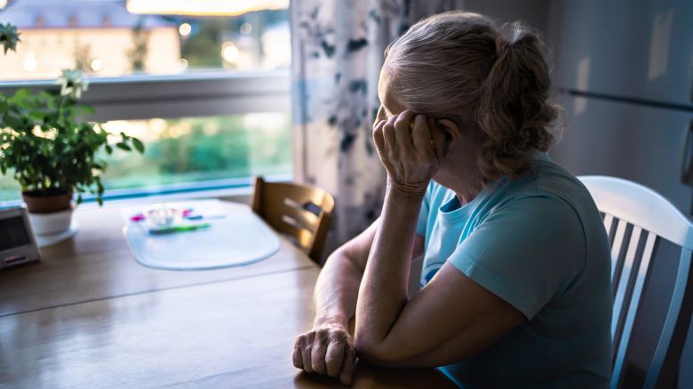 Sad old woman. Depressed lonely senior lady with alzheimer, dementia, memory loss or loneliness. Elder person looking out the home window. Sick patient with disorder. Pensive grandma. Widow with grief