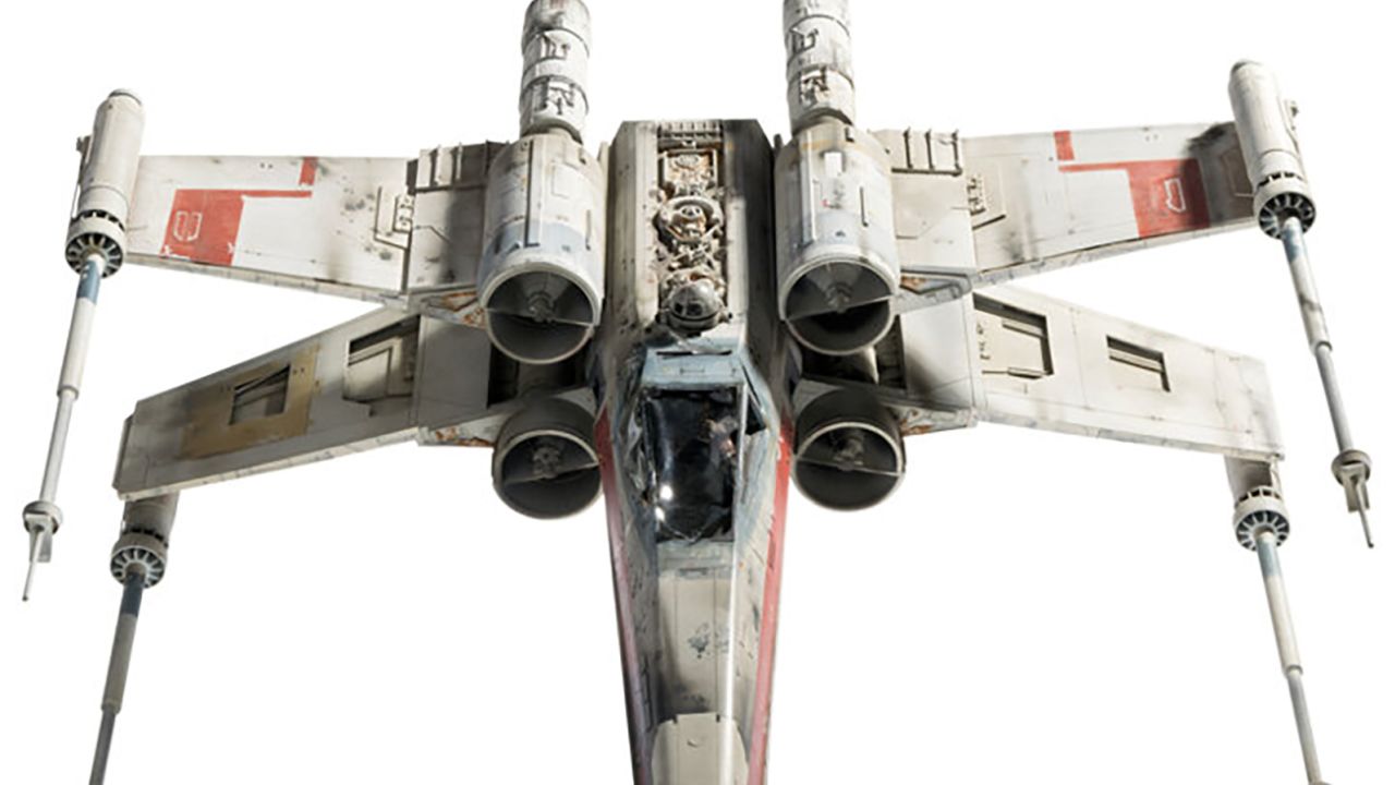 From Heritage Auctions: Screen Matched Hero "Red Leader" (Red One) X-wing Starfighter Filming Miniature with Articulating Servo-Controlled Wings and Lights from Star Wars: Episode IV- A New Hope (TCF, 1977). Built by the team at Industrial Light & Magic which won the Academy Award for Best Visual Effects for Star Wars, this 1:24 scale filming miniature is one of only four hero filming miniatures created with servo-controlled wings that spread open into "Attack Position". Constructed of resin, vacuum-formed styrene, acrylic, and metal components over an aluminum internal armature, expertly painted and finished as a battle-distressed spacecraft, replete with service wear, blast marks and heat-scorching around exhaust nozzles.