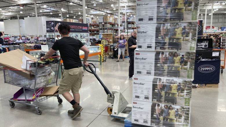 A worker guides a pallet of goods to a display spot in a Costco warehouse on July 8, 2022 in Thornton, Colo. 