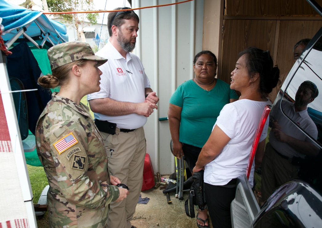 Guam residents and members of Task Force RISEUP, which is short for Roofing Installation Support Emergency Utilization Program, celebrate completion of the 100th temporary, emergency roof install during recovery efforts following Typhoon Mawar, June 27, 2023.