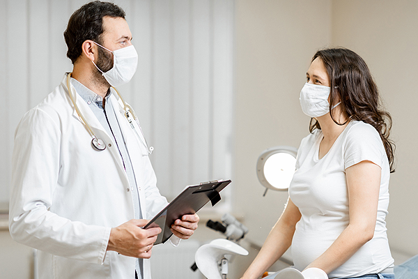 pregnant woman speaking to her doctor