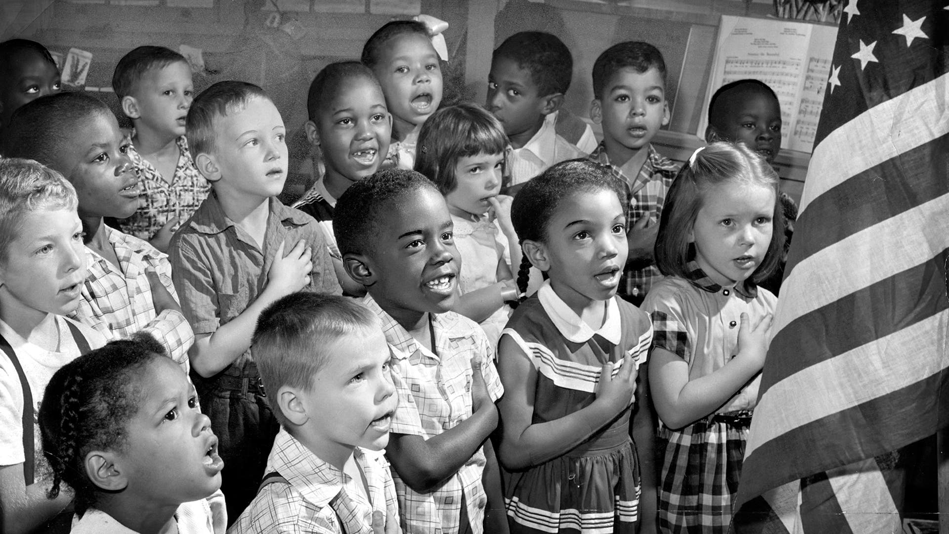 First-grade students at Public School 60 in Baltimore say the Pledge of Allegiance to the American flag in June 1955.
