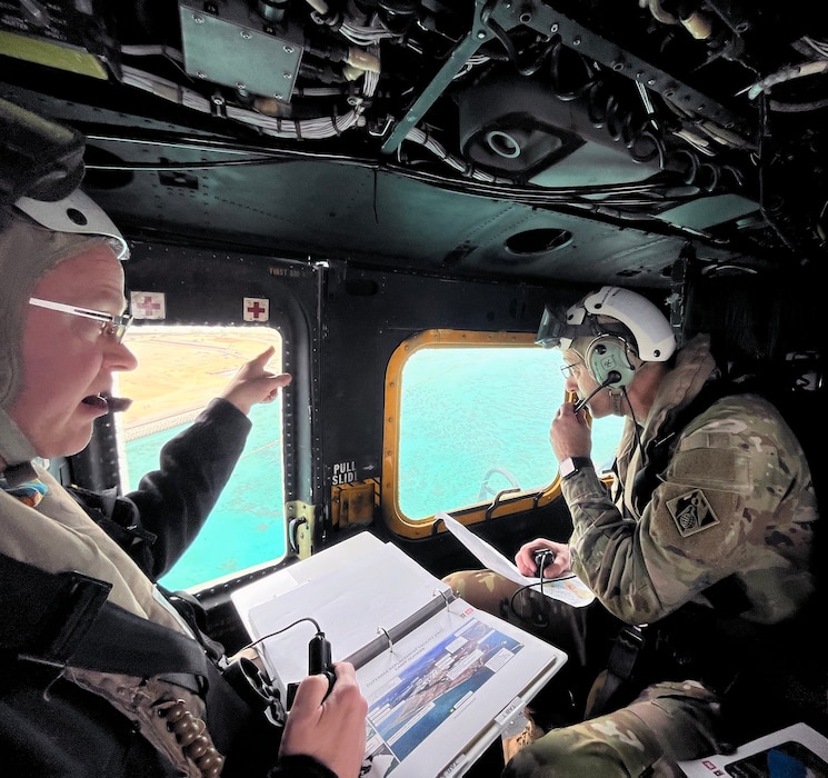 Dr. Rex Mols, Host Nation Chief for U.S. Army Corps of Engineers Japan Engineer District's Okinawa Area Office (USACE JED OAO), briefs USACE Commander, Lieutenant General Scott A. Spellmon, about ongoing construction projects from a hovering helicopter, on Okinawa, Japan.