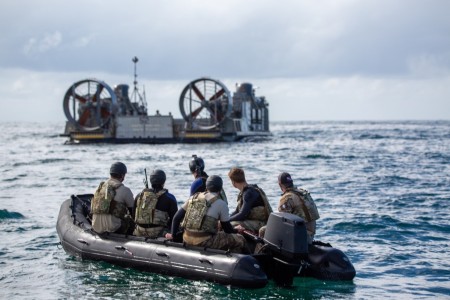 Combat divers assigned to 10th Special Forces Group prepare to land onto the Landing Craft Air Cushion (LCAC), a hovercraft, in the Pacific Ocean near Camp Pendleton, California, Oct. 23, 2023. The U.S. Navy and 10th Special Forces Group combat divers conducted joint operations by successfully navigating their zodiacs to infiltrate within intercostal and coastal waters.