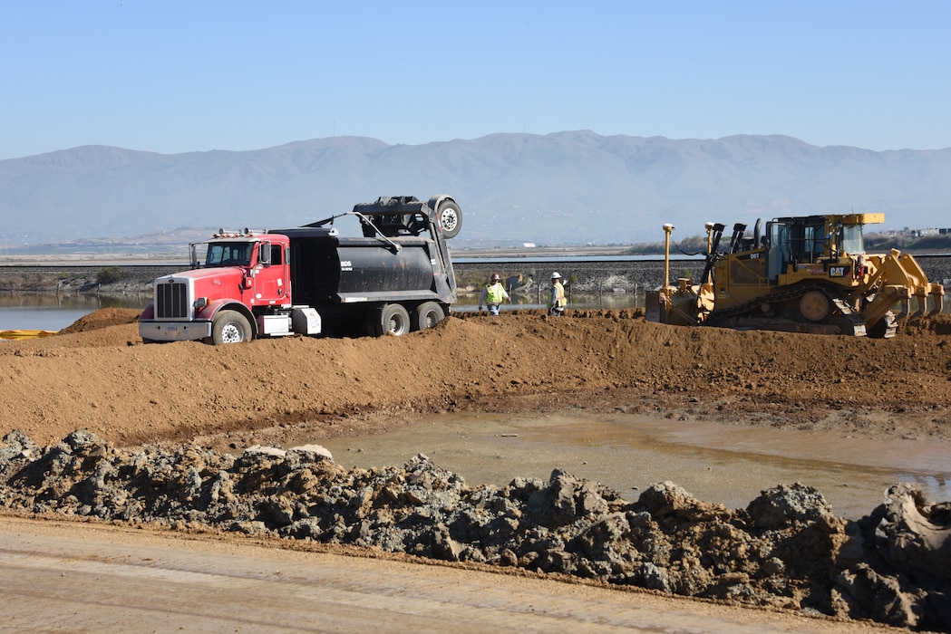 construction machinery moving dirt near water