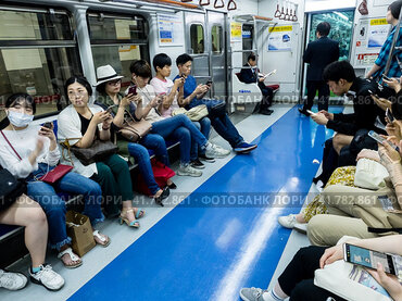 Seoul, South Korea - June 12, 2017: People sitting with mobile phones in the train in the Seoul subway