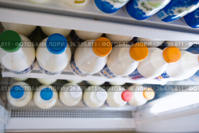 Milk bottle in a row in the supermarket, colored tube - top view