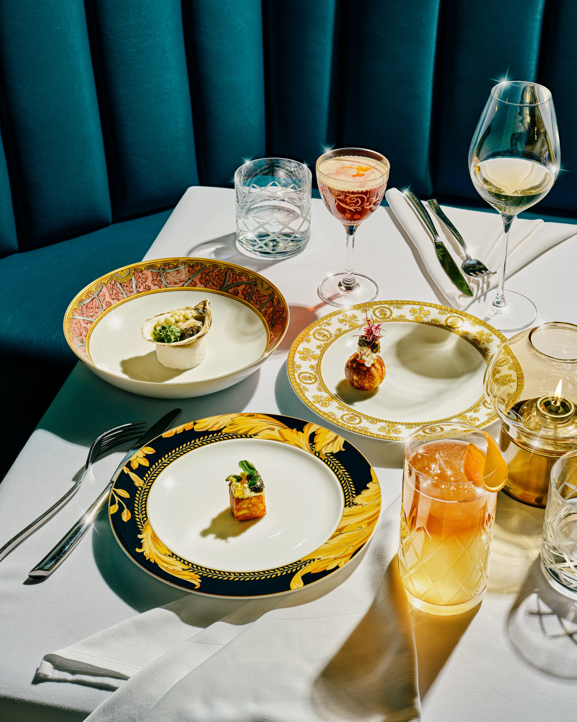 Table with gold plates, drinks, and food